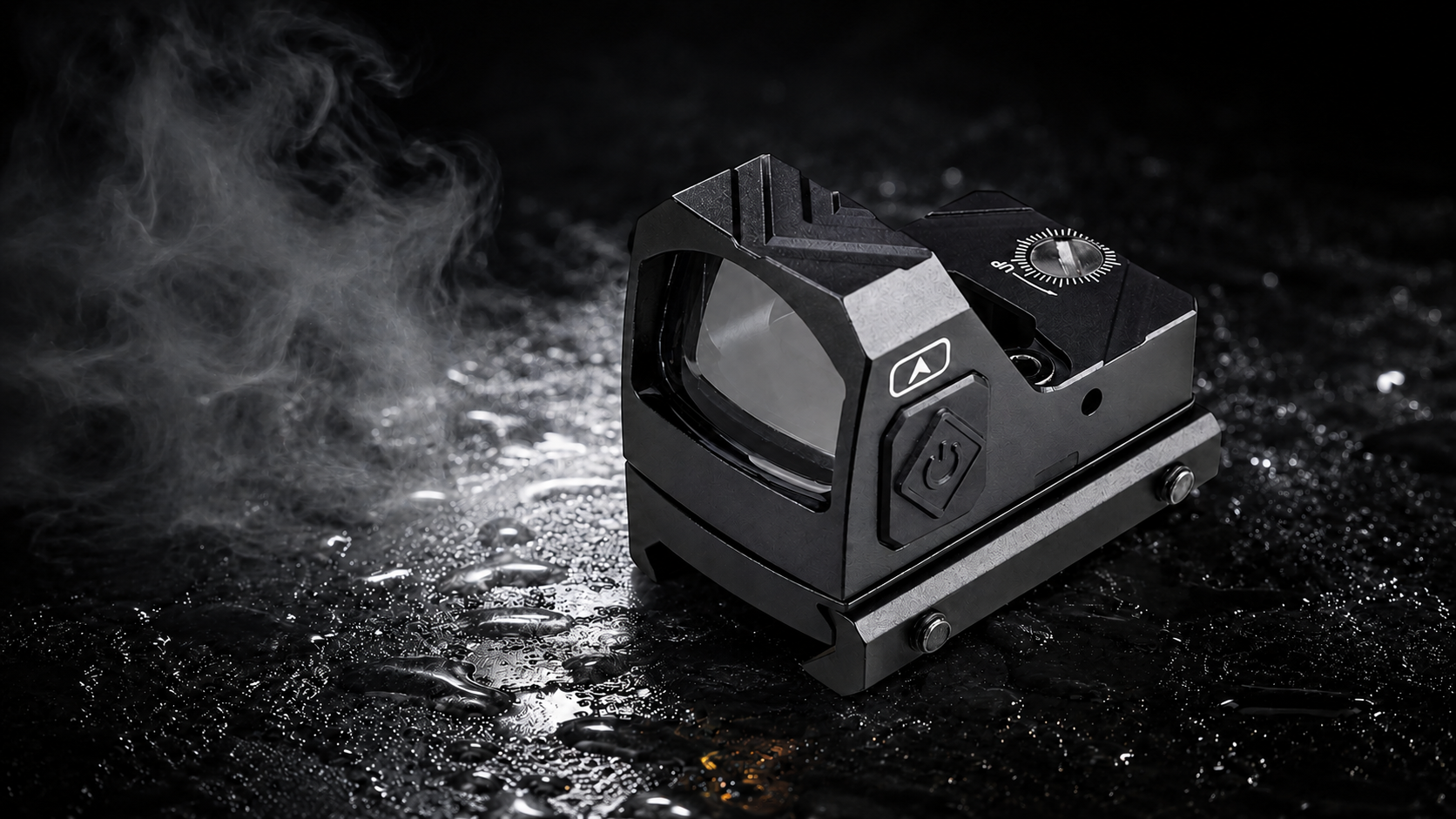 A black tactical green dot sight with a textured metal base, shown on a dark, wet surface with dramatic smoke and water droplets.
